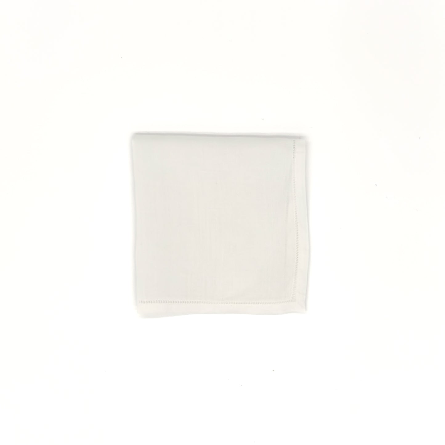 White cotton men’s handkerchief with hemstitch border, 20″ square, folded into a square.