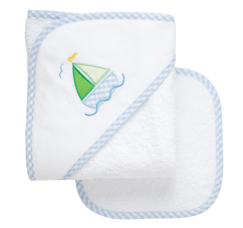 White hooded baby towel with blue sailboat appliqué; matching washcloth shown.