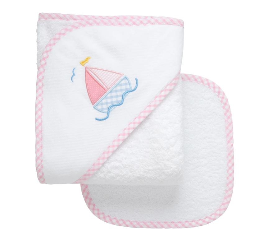 White hooded baby towel with pink sailboat appliqué; matching washcloth shown.