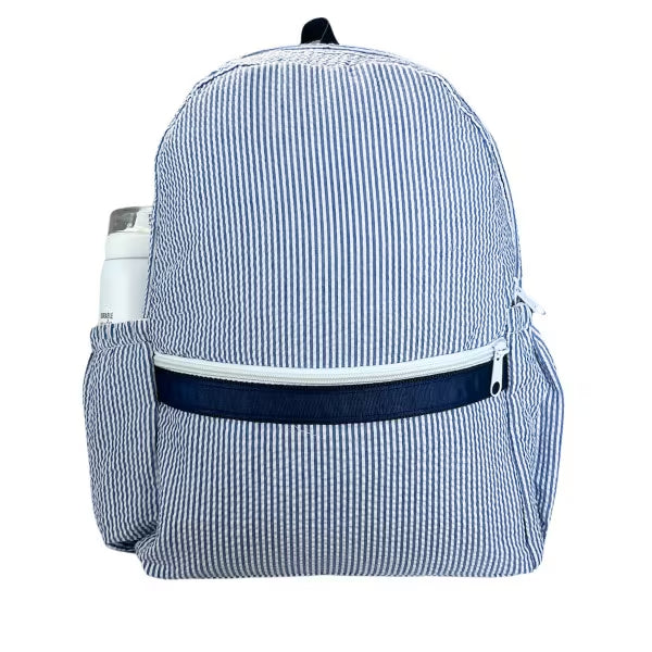 Medium kids’ backpack in navy seersucker stripes; front zip pocket and two side bottle pockets. Add custom embroidery along the top front of the backpack.